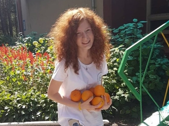 Woman holding oranges.